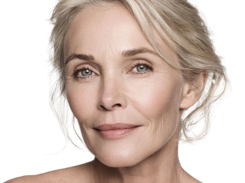 Infos zu Facelifting Münchenchen Frau mittleren Alters mit blonden hochgesteckten Haaren blickt in die Kamera